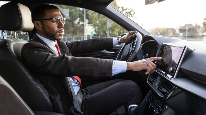 Man driving in car setting GPS