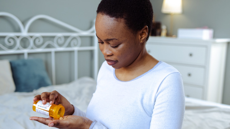 Woman emptying medication into her hand