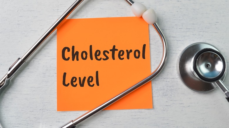 stethoscope and paper with "Cholesterol Level" text