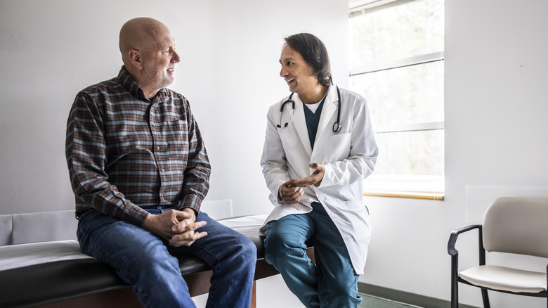 Doctor discussing treatment with senior man in exam room