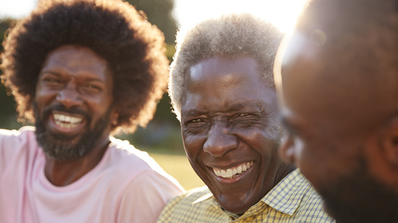 Senior black man laughing with his sons