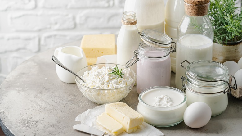 Fresh dairy products like milk, cottage cheese, yogurt, sour cream and butter on kitchen table