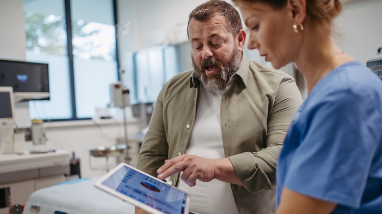 Female doctor consulting with overweight male patient