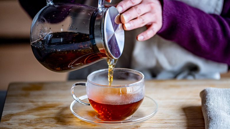 person pouring tea