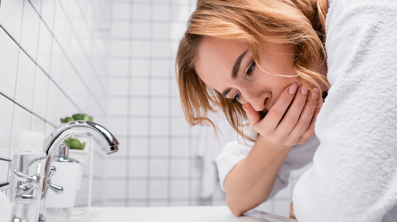 woman leaning over sink 