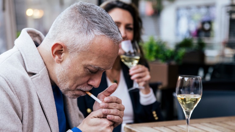 Older man lighting a cigarette