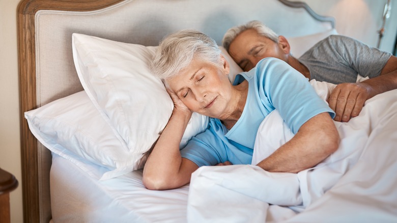 Old couple asleep in bed