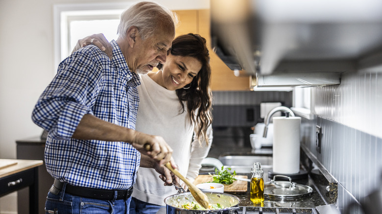 Older couple cooking together in kitchen