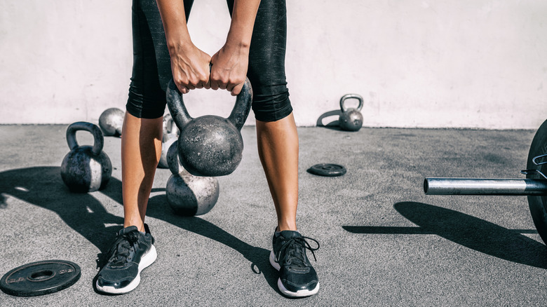 A woman uses a kettlebell to work out