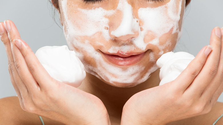 woman putting foam on face 