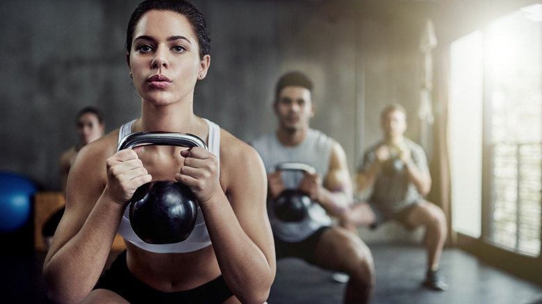 woman holding a kettlebell in fitness class