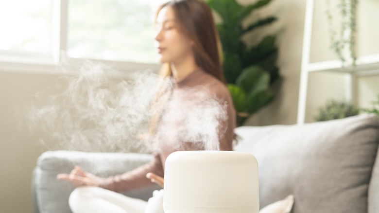 humidifier with woman meditating in background