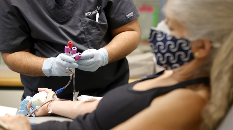 women getting blood drawn by phlebotomist