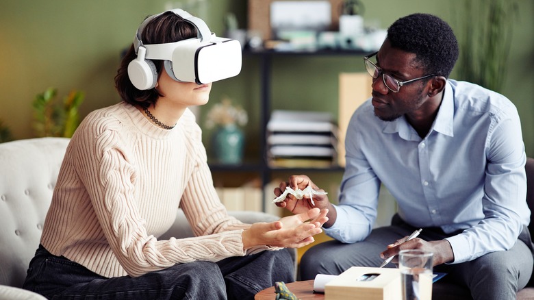 therapist handing client with VR headset fake spider