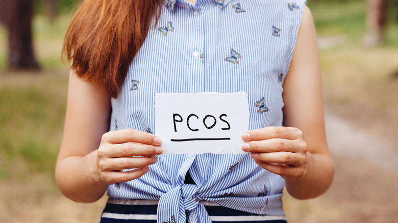 woman holding PCOS on paper