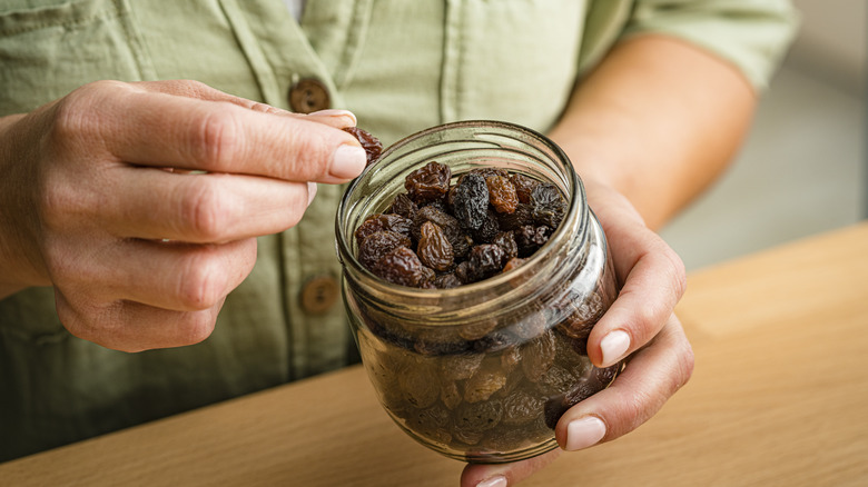 person eating granola with raisins