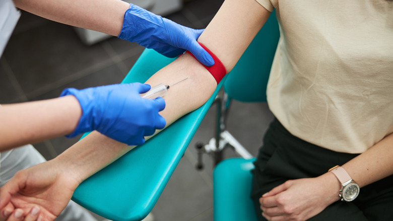 Phlebotomist performs a blood test on patient