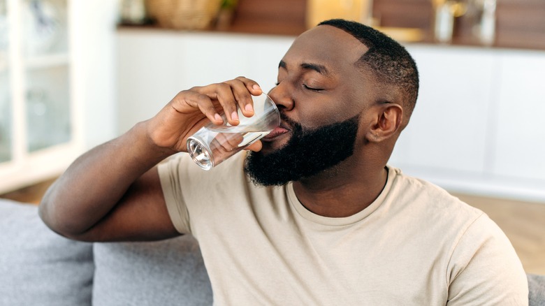 Smiling man drinking water