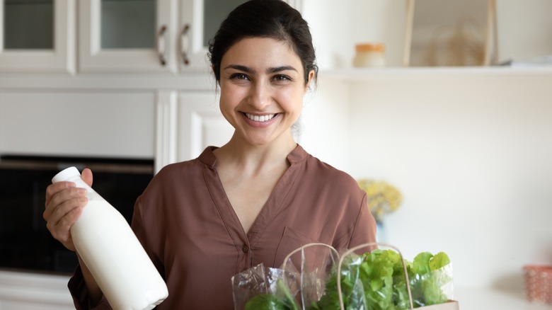 Smiling woman holding groceries