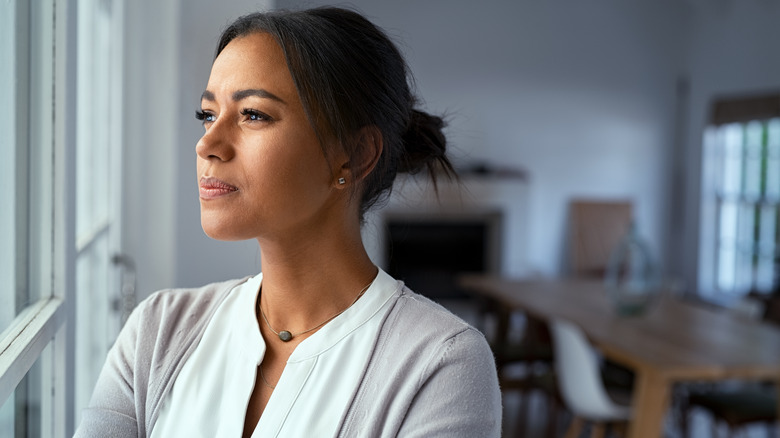 Anxious woman looking out window