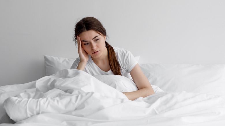 Anxious woman lying in bed