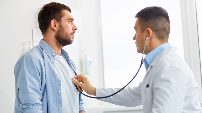 doctor listens to man with stethoscope