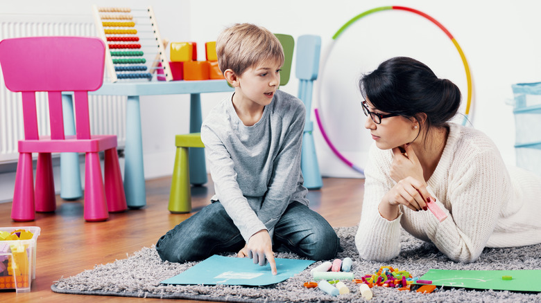 Child working with teacher on art project