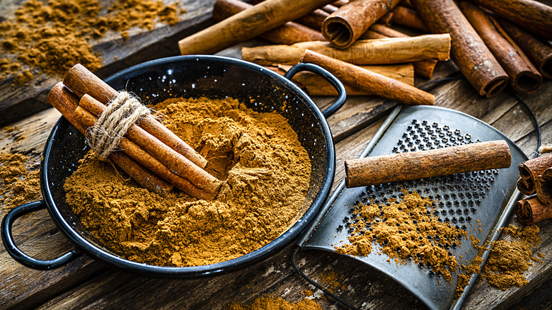 cinnamon sticks in a bowl of freshly grated cinnamon