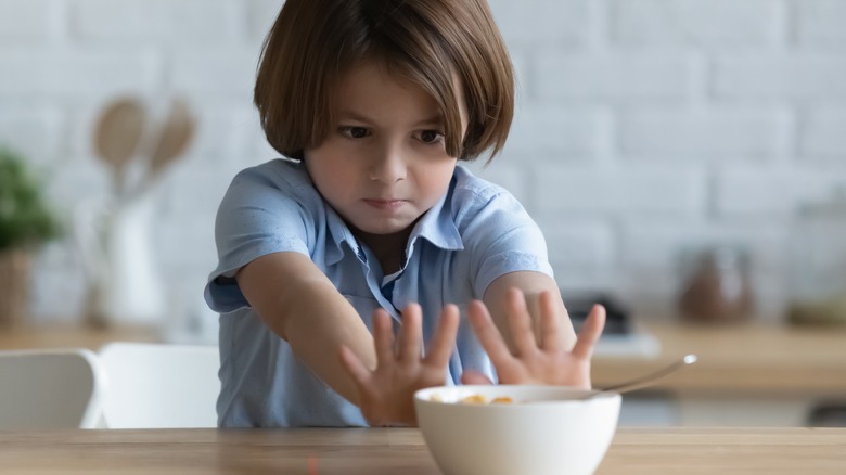 Child pushing bowl of food away