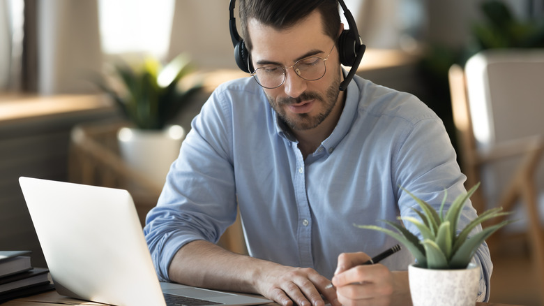 Man at desk with headphones working