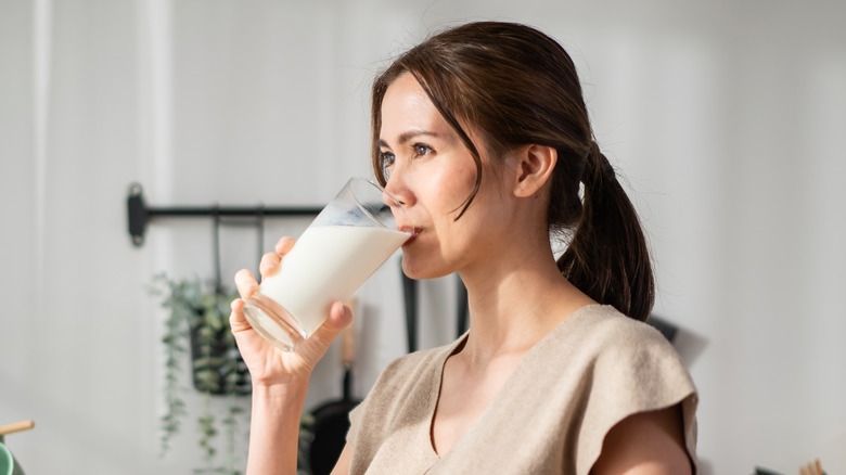 woman drinking milk in her kitchen