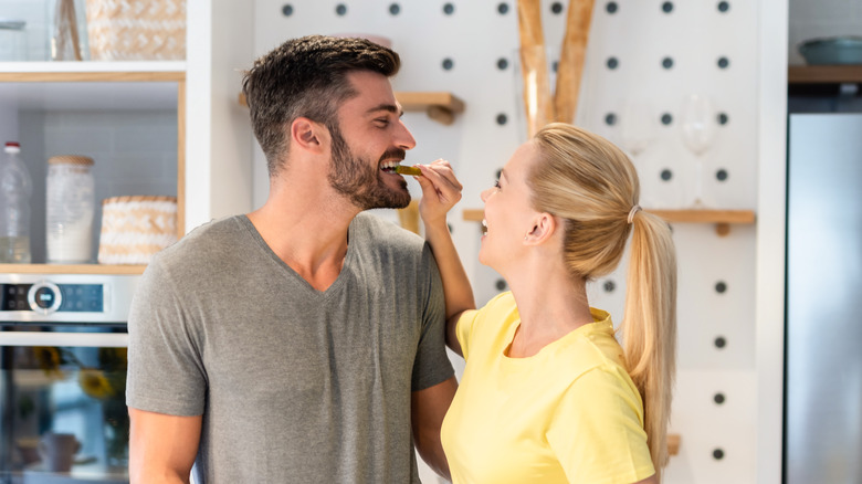 woman putting food in partner's mouth
