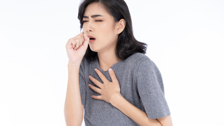Woman coughing with white background