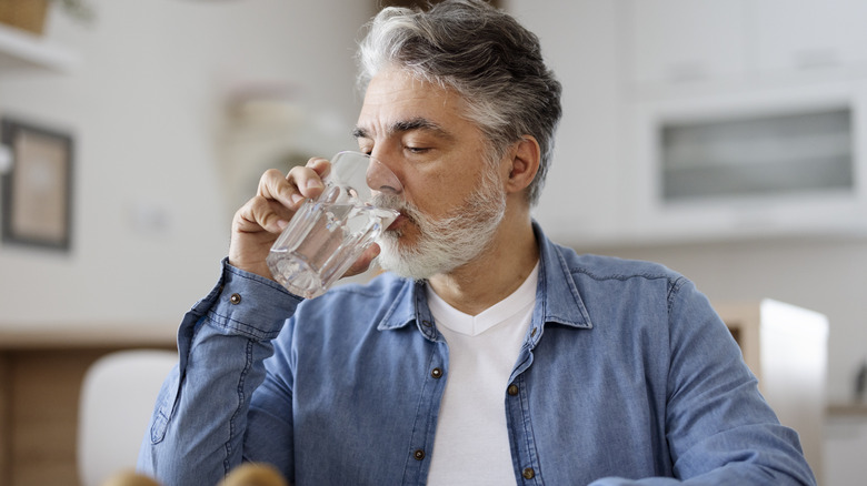 middle age man drinking a glass of water