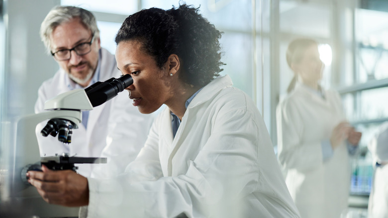 A scientist looking through a microscope