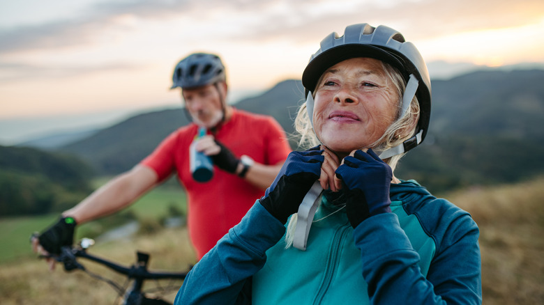 A senior couple wearing bicycle helmets stopping during a bike ride