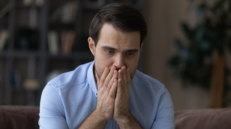 worried man covering mouth