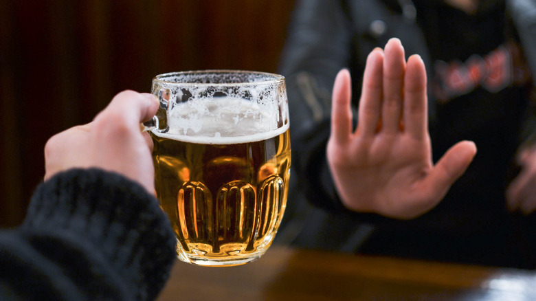 hand rejecting glass of beer