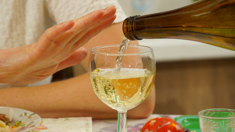 Woman signaling that she's had enough wine