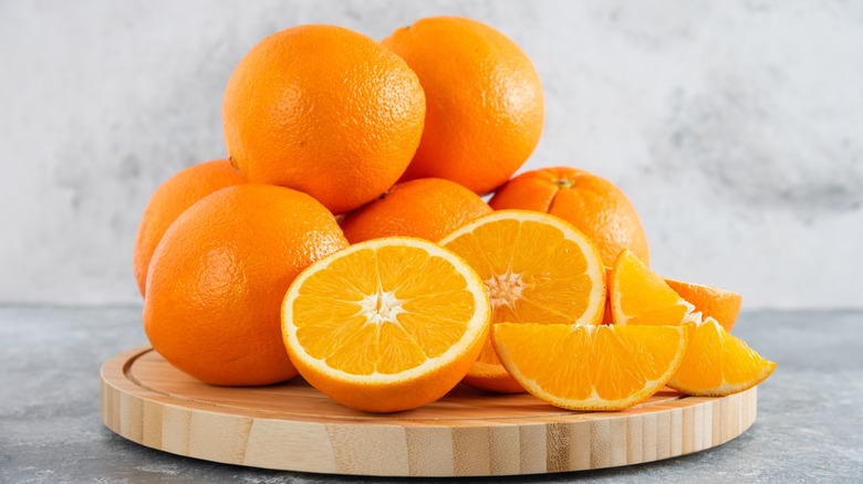 stack of oranges on a wood tray
