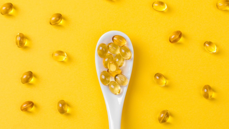 Vitamin E capsules on yellow background