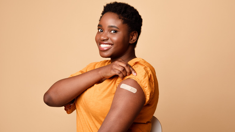 woman smiling with band-aid on arm