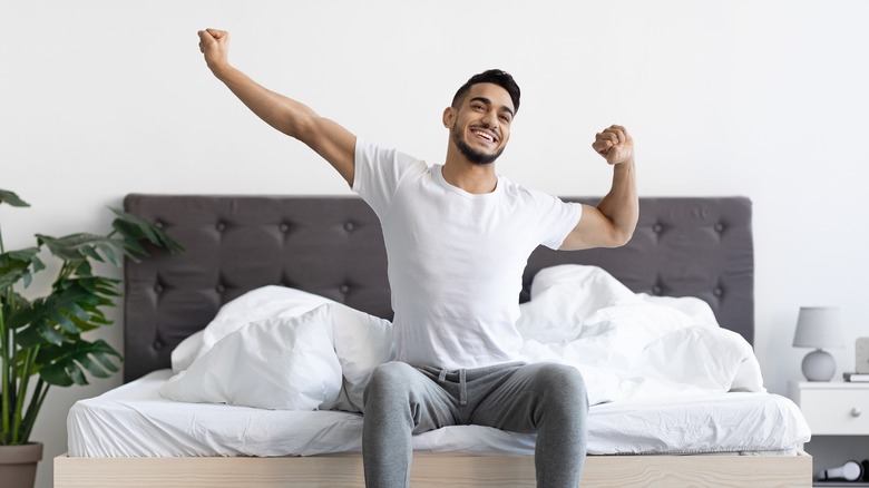 man waking up refreshed in bed