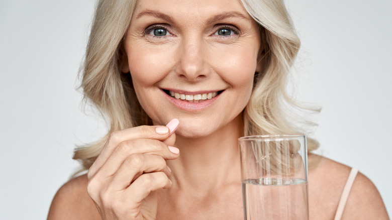 Woman taking medication with water