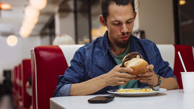 man holding burger restaurant