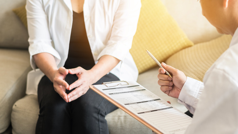 A woman speaks with a doctor about her symptoms