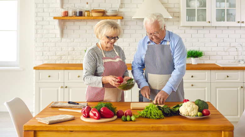 an older couple cooking together 