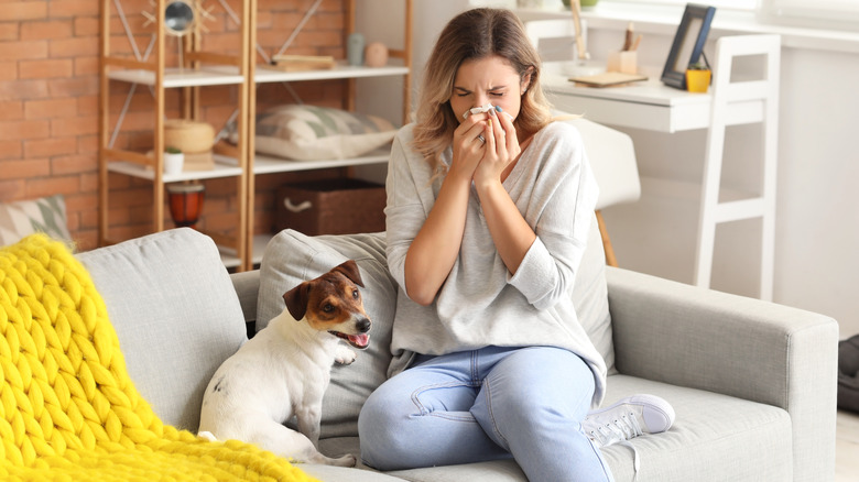 woman on couch sneezing