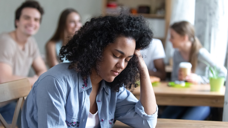 Stressed woman at a social gathering, social anxiety