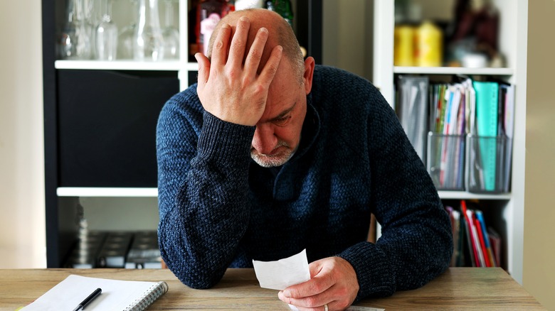 Frustrated man looking at paper 